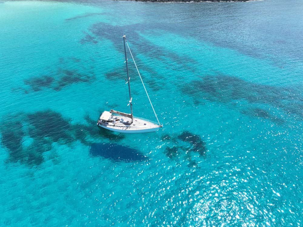 Segelbåt för ankar i vatten där man ser botten.